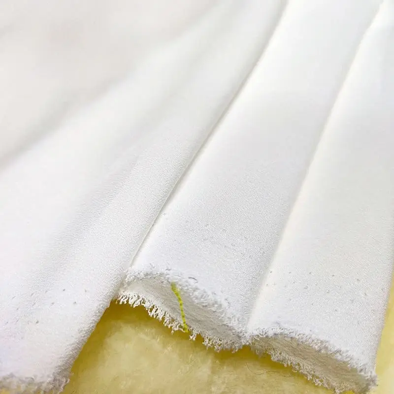 Close-up view of Crepe de Chine fabric showing its soft texture and sheen