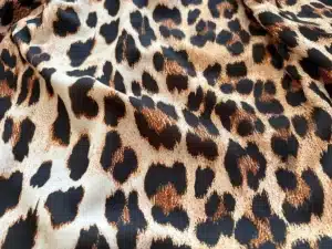 fabric-table.webp Folded animal print fabric by the yard and geometric pattern fabric on designer's table